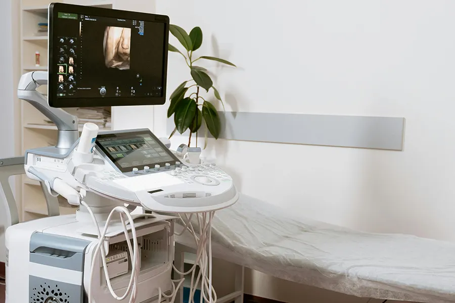 Two screen machine next to beedd in a clinic room Clean Clinic Environment